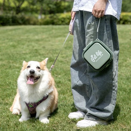 Propriétaire tenant son chien en laisse et  la Gamelle chien Portable Double Compartiment.