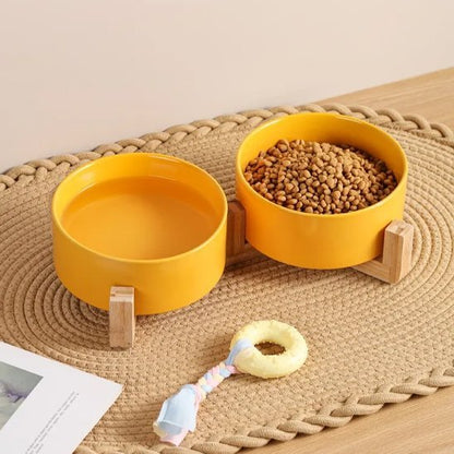 Gamelle chien surélevée Design Digest en couleur jaune sur tapis tissé.